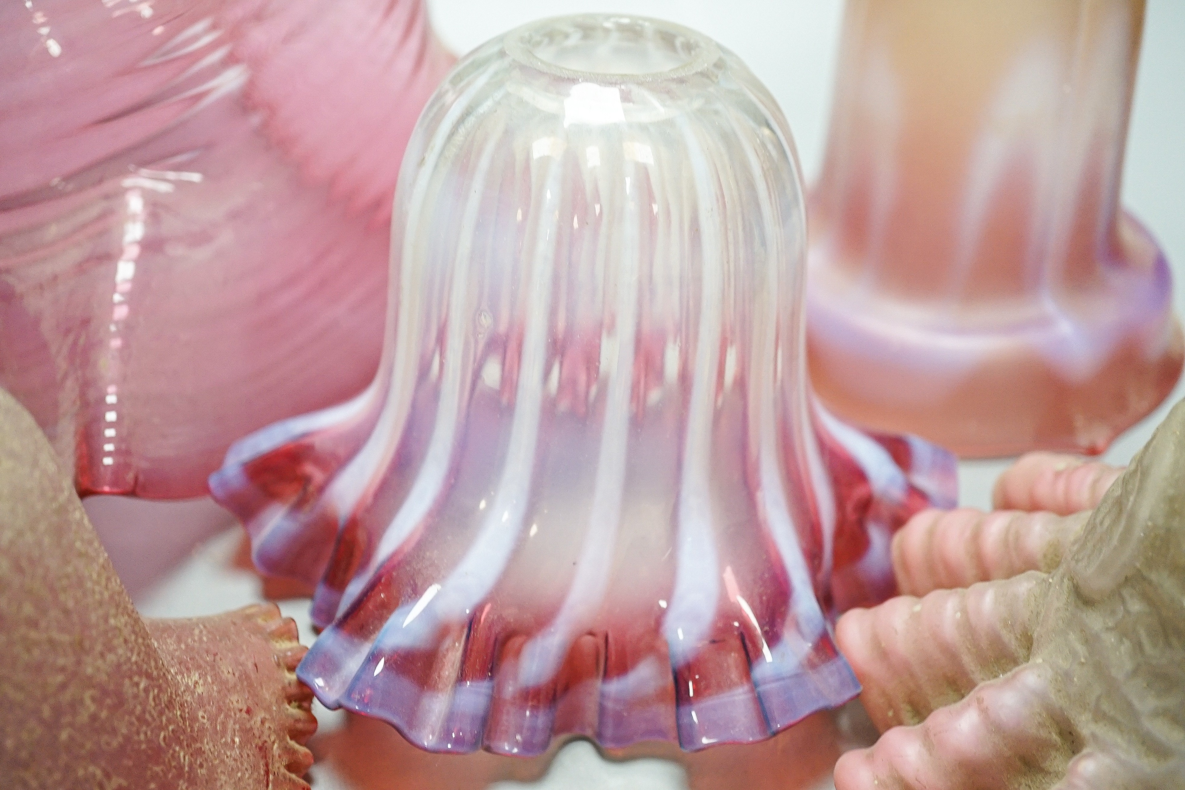 Six various cranberry glass lamp shades, two with opalescence, largest 16 cms high.